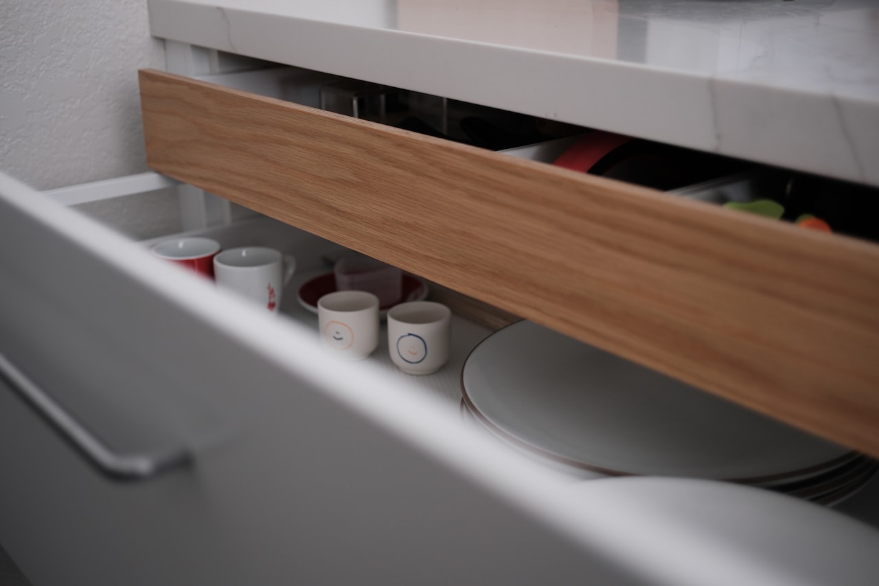An open kitchen drawer with a white oak drawer front.